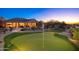 Putting green and home exterior at dusk at 10756 E Ludlow Dr, Scottsdale, AZ 85255