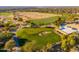 Aerial view of a lush golf course with players and clubhouse at 10756 E Ludlow Dr, Scottsdale, AZ 85255