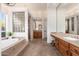 Large bathroom with a soaking tub, double vanity, and glass block accents at 10756 E Ludlow Dr, Scottsdale, AZ 85255