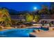 Luxury pool and spa with waterfall feature at night at 10756 E Ludlow Dr, Scottsdale, AZ 85255