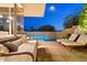 Night view of a relaxing patio with a pool at 10758 E Tamarisk Way, Scottsdale, AZ 85262