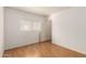 Bedroom with wood flooring, window, and door to hallway at 11793 W Larkspur Rd, El Mirage, AZ 85335