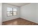 Bedroom with wood flooring, window, and view of parking at 11793 W Larkspur Rd, El Mirage, AZ 85335