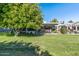 Landscaped backyard with a large tree and grassy area at 12719 W Shadow Hills Dr, Sun City West, AZ 85375