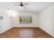 Spacious bedroom with wood-look flooring, ceiling fan, and large window allowing ample natural light at 1328 E Binner Dr, Chandler, AZ 85225