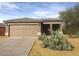 Front exterior of home showcasing a 2-car garage, mature desert vegetation and covered front patio at 14 E Peppergrass Pl, San Tan Valley, AZ 85143