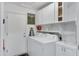 Well-lit laundry room with white cabinets, shelving, and a washer and dryer at 14 E Peppergrass Pl, San Tan Valley, AZ 85143