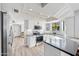 Modern kitchen with white cabinets, gray countertops, and wood-look flooring at 1436 E Rosemonte Dr, Phoenix, AZ 85024