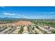 Aerial view of a neighborhood near mountains and a large undeveloped area at 15913 W Elm St, Surprise, AZ 85374