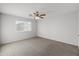 Simple bedroom with carpet, large window, and ceiling fan at 15913 W Elm St, Surprise, AZ 85374