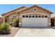 Tan one-story house with a two-car garage and desert landscaping at 15913 W Elm St, Surprise, AZ 85374