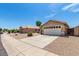 Tan one-story house with a two-car garage and desert landscaping at 15913 W Elm St, Surprise, AZ 85374