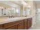 Double vanity bathroom with dark wood cabinets and a large mirror at 16955 W Holly St, Goodyear, AZ 85395