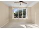 Spacious bedroom featuring a large window with plantation shutters and ceiling fan at 16955 W Holly St, Goodyear, AZ 85395