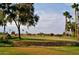 Golf course view with stone wall and lush landscaping at 16955 W Holly St, Goodyear, AZ 85395