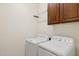 Laundry room with washer, dryer, and cabinets at 16955 W Holly St, Goodyear, AZ 85395