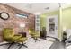 Cozy sitting area with olive green armchairs and a brick accent wall at 1837 E Minnezona Ave, Phoenix, AZ 85016