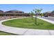 Curved concrete path and lawn area in a community park at 20775 N Roadrunner Ln, Maricopa, AZ 85138