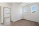 Small bedroom with hardwood floors and two windows at 2125 E Voltaire Ave, Phoenix, AZ 85022