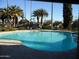 Refreshing kidney-shaped pool surrounded by palm trees at 2208 W Lindner Ave # 17, Mesa, AZ 85202