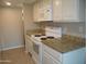 Kitchen with granite countertops, white cabinets, and electric range at 2208 W Lindner Ave # 17, Mesa, AZ 85202