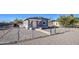 House exterior with gray stucco, chain link fence, and gravel driveway at 232 S San Carlos St, Florence, AZ 85132