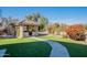 Relaxing backyard featuring a covered patio, artificial grass, and well-maintained landscaping at 2418 E Glass Ln, Phoenix, AZ 85042