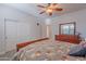 Spacious bedroom features an ensuite bathroom, ceiling fan and a dresser with a mirror at 2418 E Glass Ln, Phoenix, AZ 85042