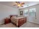 Traditional bedroom with a decorative bedspread, a ceiling fan, a nightstand and two windows at 2418 E Glass Ln, Phoenix, AZ 85042