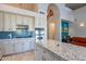 Contemporary kitchen featuring stainless steel appliances, white cabinets, and a large island with granite countertops at 2418 E Glass Ln, Phoenix, AZ 85042