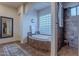 Spa-like bathroom with soaking tub, walk-in shower, and glass block window at 32029 N 19Th Ln, Phoenix, AZ 85085