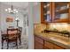 Butlers pantry with granite countertop and glass-front cabinets at 32029 N 19Th Ln, Phoenix, AZ 85085