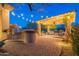 Built-in outdoor kitchen with pergola and string lights at 32029 N 19Th Ln, Phoenix, AZ 85085