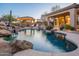 Stunning pool with a cascading waterfall, surrounded by lush landscaping and a covered patio at 32029 N 19Th Ln, Phoenix, AZ 85085