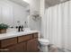 Modern bathroom with wood vanity, chevron shower curtain, and storage at 32040 N Lisadre Ln, San Tan Valley, AZ 85144