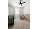 Cozy Bedroom with carpeted floors, a dark crib, comfortable chair, dresser, and a ceiling fan for a relaxing environment at 32040 N Lisadre Ln, San Tan Valley, AZ 85144