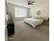 Comfortable bedroom with carpeted floors, neutral walls, a ceiling fan, and a large window for natural light at 32040 N Lisadre Ln, San Tan Valley, AZ 85144
