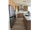 Bright kitchen with stainless steel appliances, a spacious central island, and warm wood toned cabinets and flooring at 32040 N Lisadre Ln, San Tan Valley, AZ 85144
