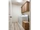 Bright laundry room includes white washer and dryer, upper cabinets, and wood-look flooring at 32040 N Lisadre Ln, San Tan Valley, AZ 85144