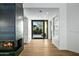 View of the modern entrance with a fireplace, wood floors, and a sliding glass door at 39493 N 107Th Way, Scottsdale, AZ 85262