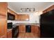 Modern kitchen with wood cabinets, black appliances, and track lighting at 5122 E Shea Blvd # 1005, Scottsdale, AZ 85254