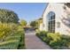 Exterior view of a luxury home with a large window, brick path, and beautiful green hedges at 5203 N Monte Vista Dr, Paradise Valley, AZ 85253