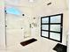 A modern bathroom features a glass enclosed shower with black hardware and a sliding panel door at 5748 W Soft Wind Dr, Glendale, AZ 85310