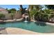 A cool custom pool features a rock waterfall and lush landscaping at 5748 W Soft Wind Dr, Glendale, AZ 85310