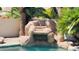 A custom pool features a rock waterfall, lush landscaping, and cool clear water at 5748 W Soft Wind Dr, Glendale, AZ 85310