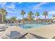 Community pool with lounge chairs and palm trees at 755 E Zion Dr # 103, Gilbert, AZ 85297