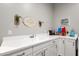 Clean laundry room with white cabinets and a utility sink at 8308 W Avenida Del Sol --, Peoria, AZ 85383