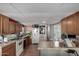 View of kitchen with wood cabinets, appliances, and breakfast bar at 9501 E Broadway Rd # 178, Mesa, AZ 85208