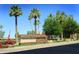 Entrance to Oakwood Country Club, featuring palm trees and a welcoming sign at 9509 E Arrowvale Dr, Sun Lakes, AZ 85248