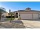 House exterior showcasing a two-car garage and well-manicured lawn at 9509 E Arrowvale Dr, Sun Lakes, AZ 85248